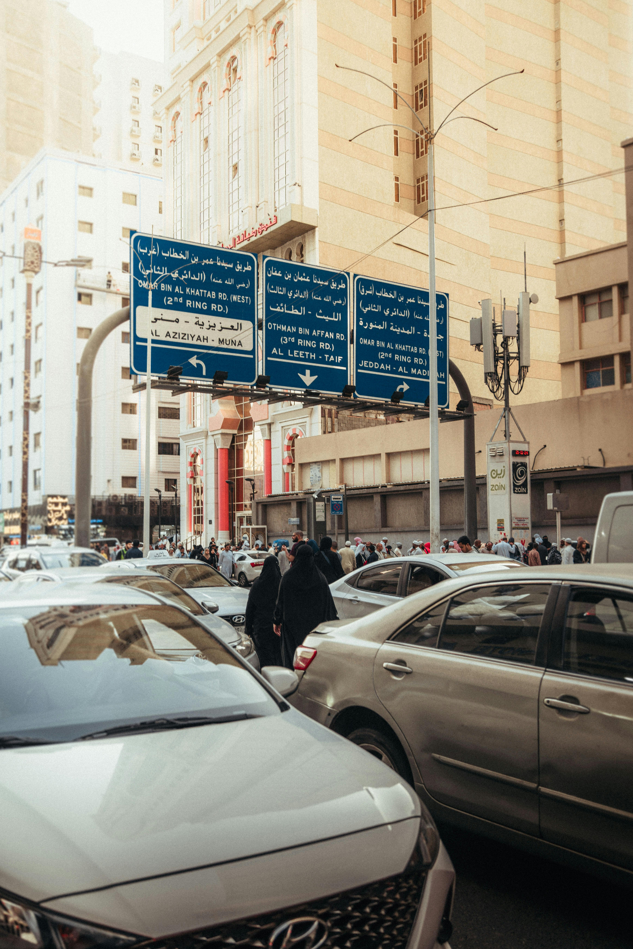 Bilingual street signs on a busy road in Makkah