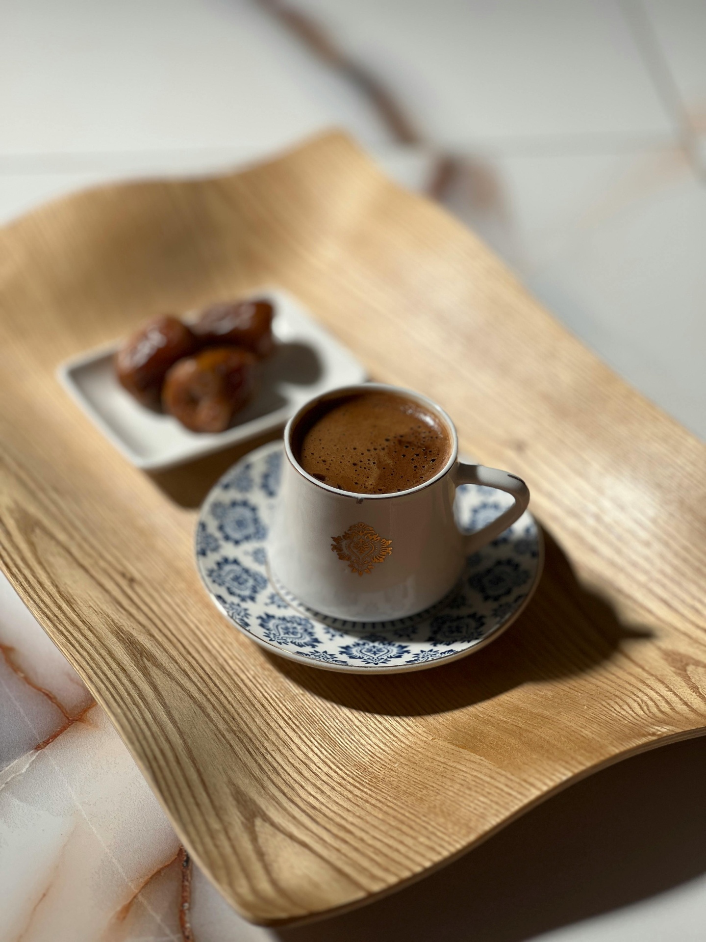 Arabic coffee served with dates on a wooden tray